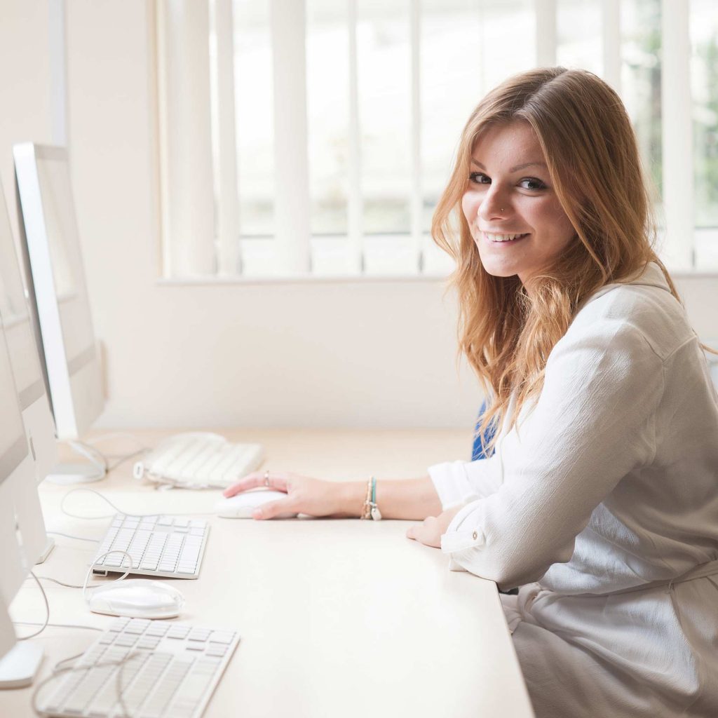 Female student at a computer desk smiling