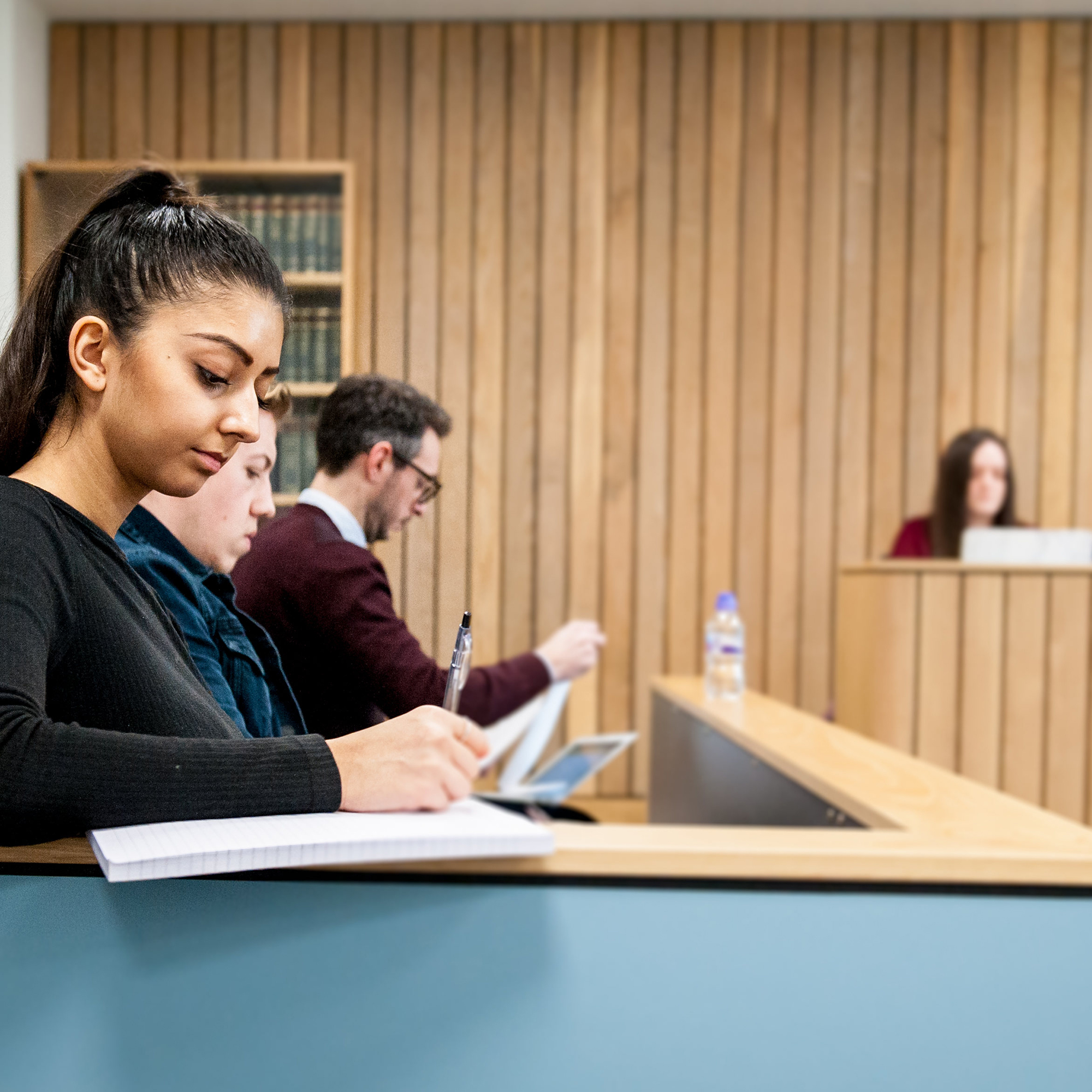 Students on Forensic Psychology course taking notes in Moot room at Oxstalls campus
