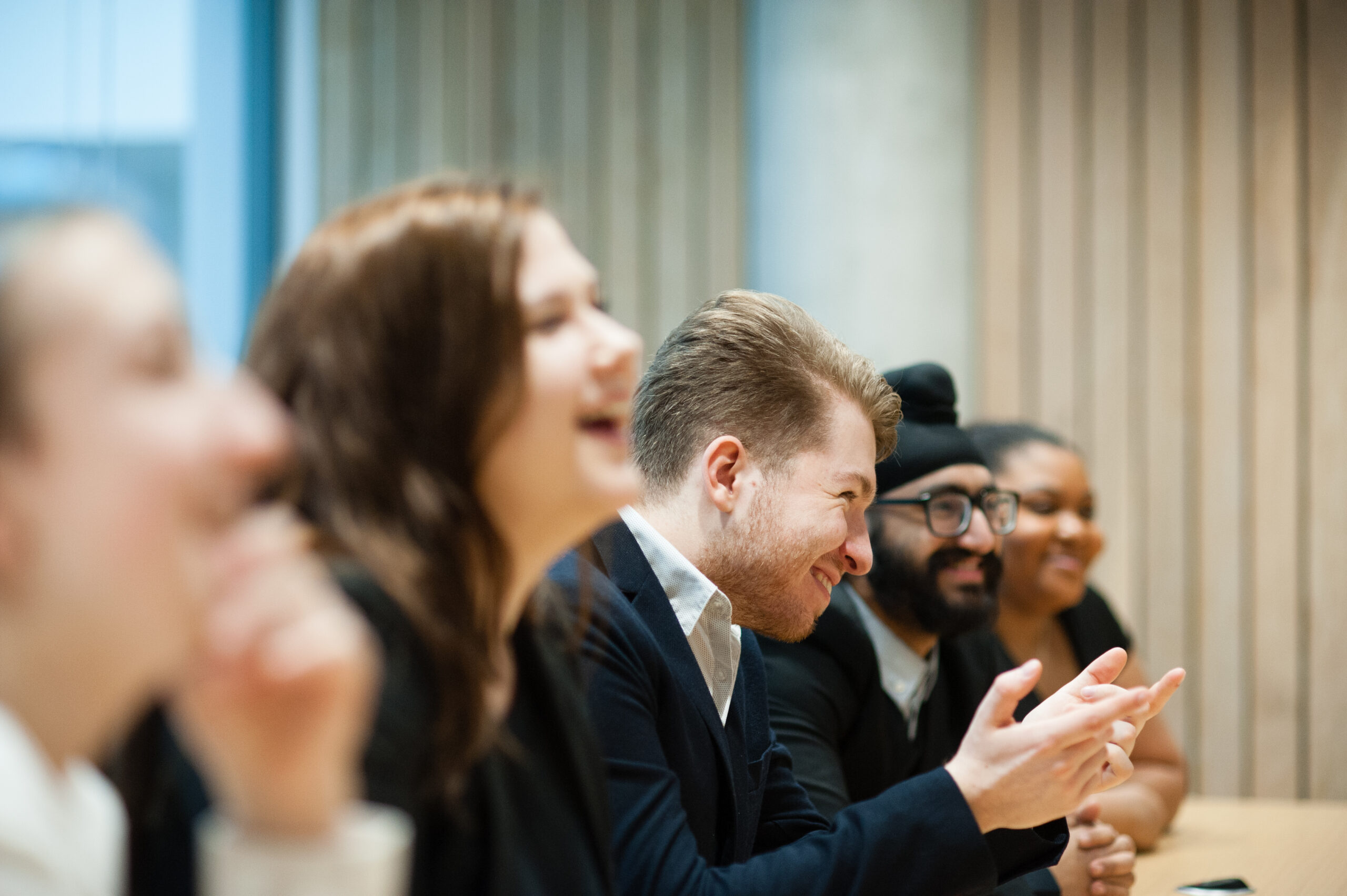 a side-on shot of five students who are laughing