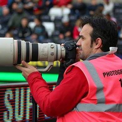 Paul Roberts at a sports event taking photos with a long range camera lens.
