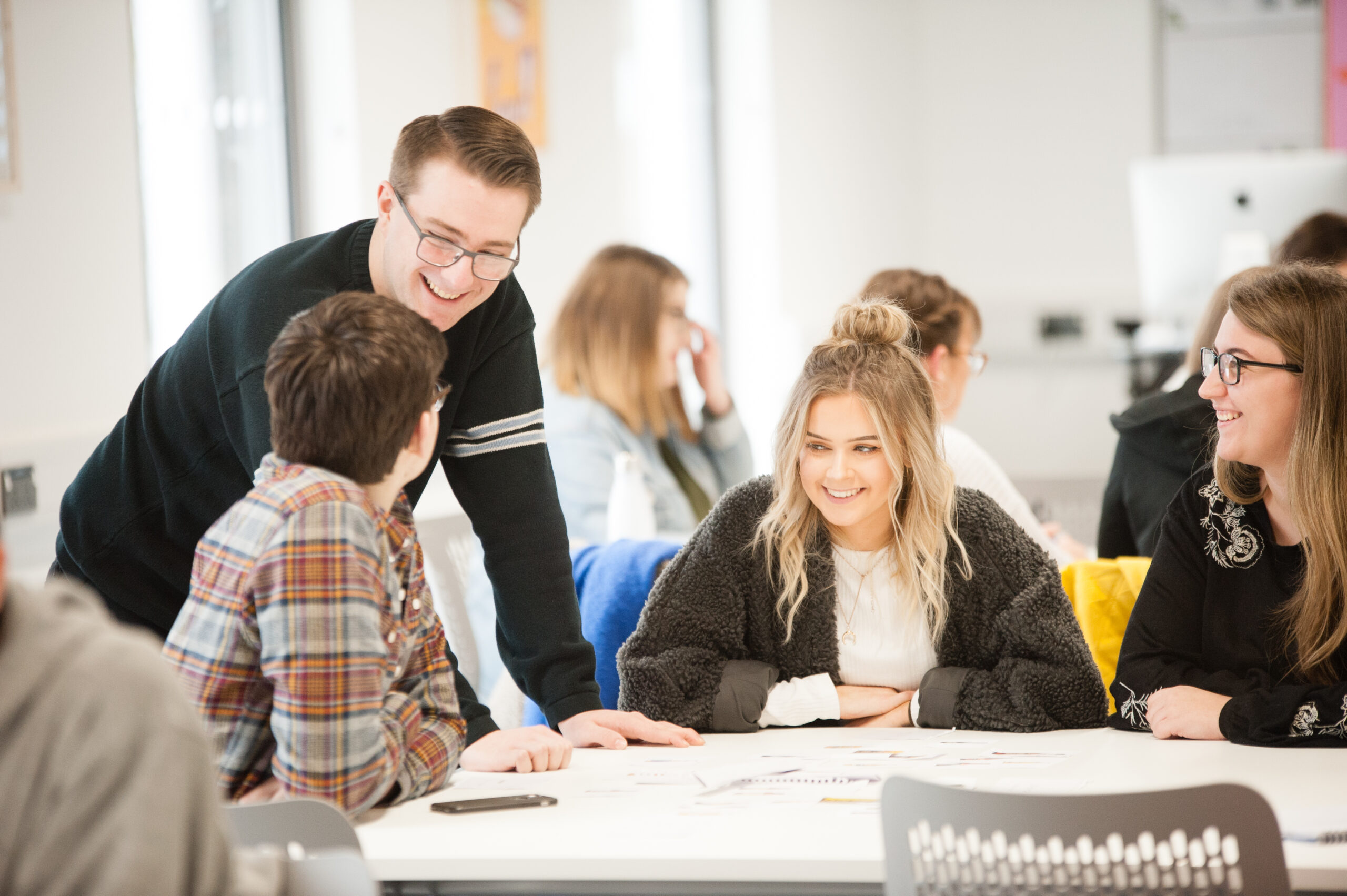 student talking while sat around a table