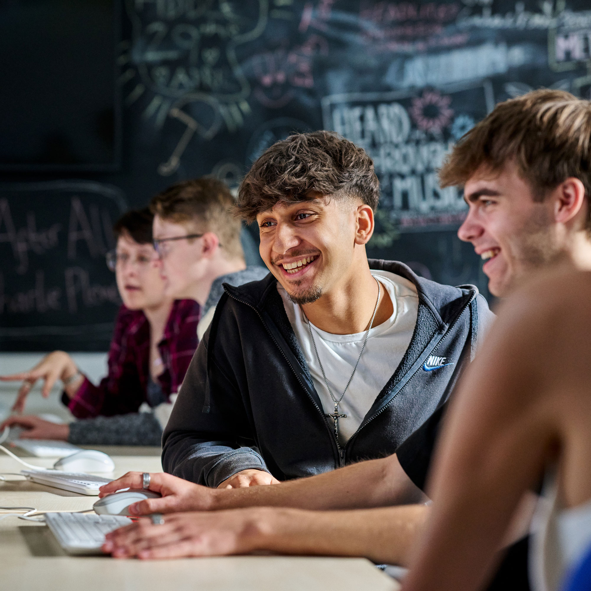 Students working at computers smiling