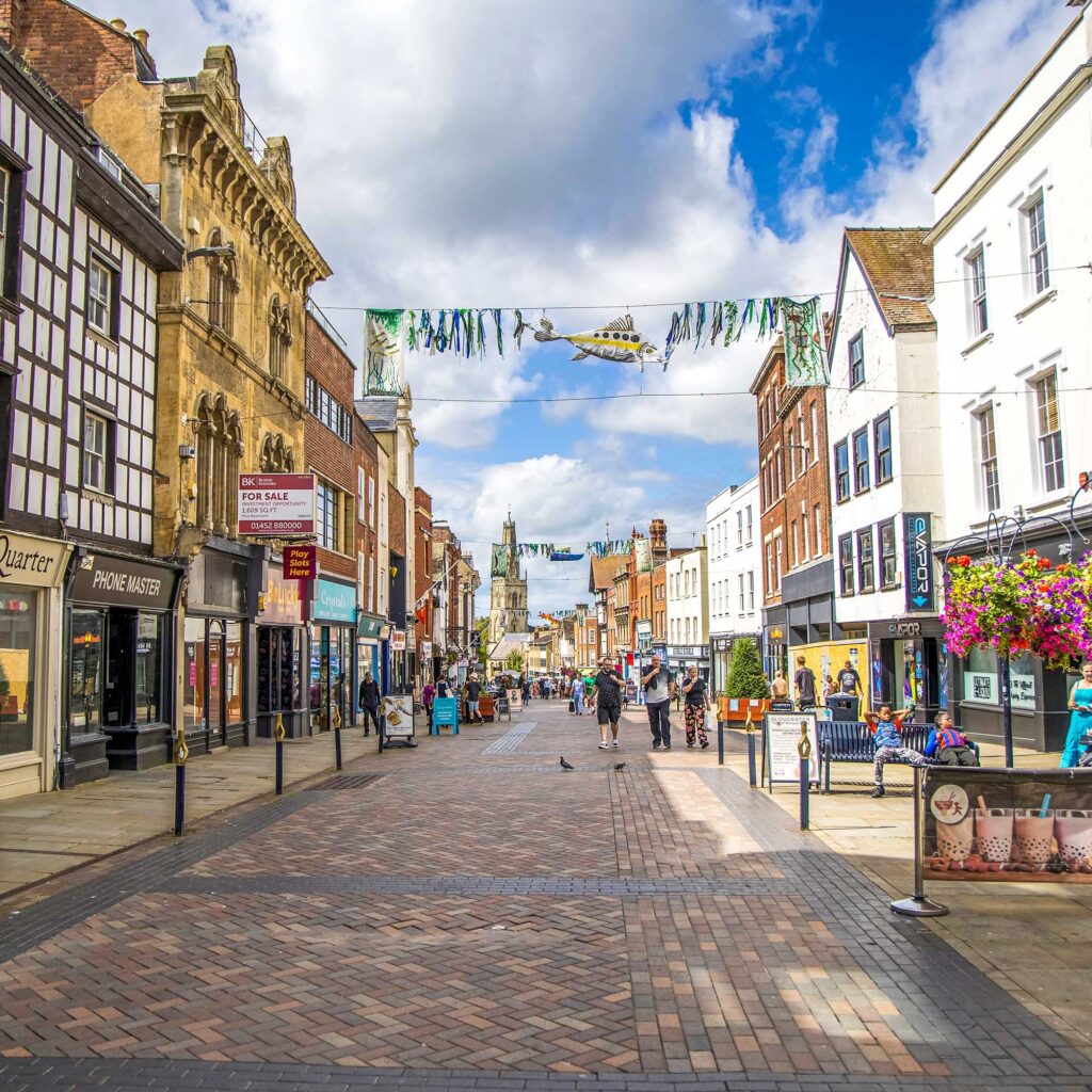 Gloucester city centre showing a pedestrianised road of shops.
