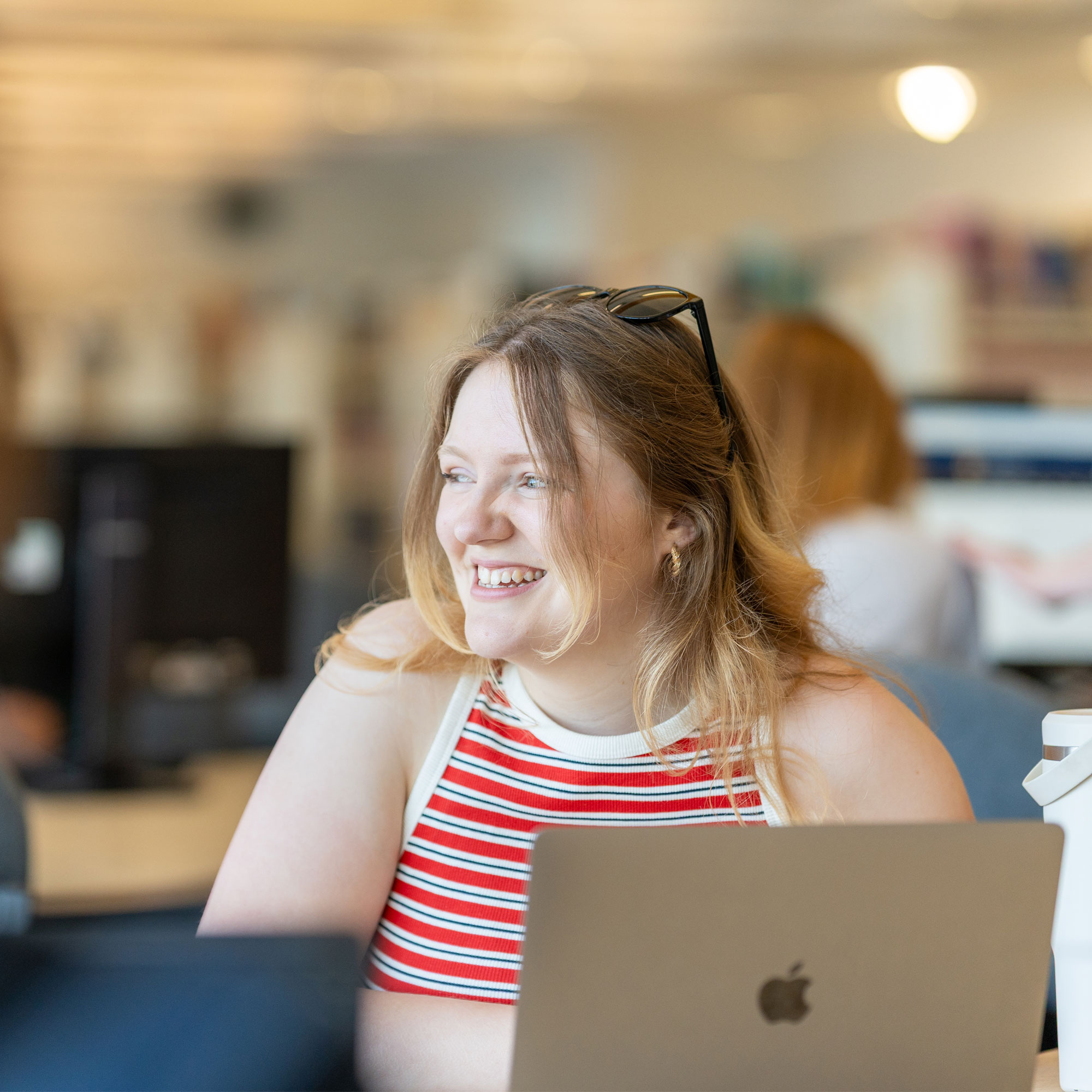 A student sat in the library smiling