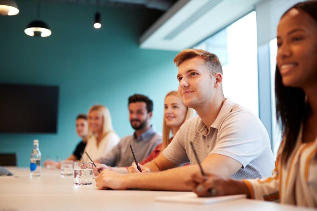 Students sitting at a table with paper and pencils.