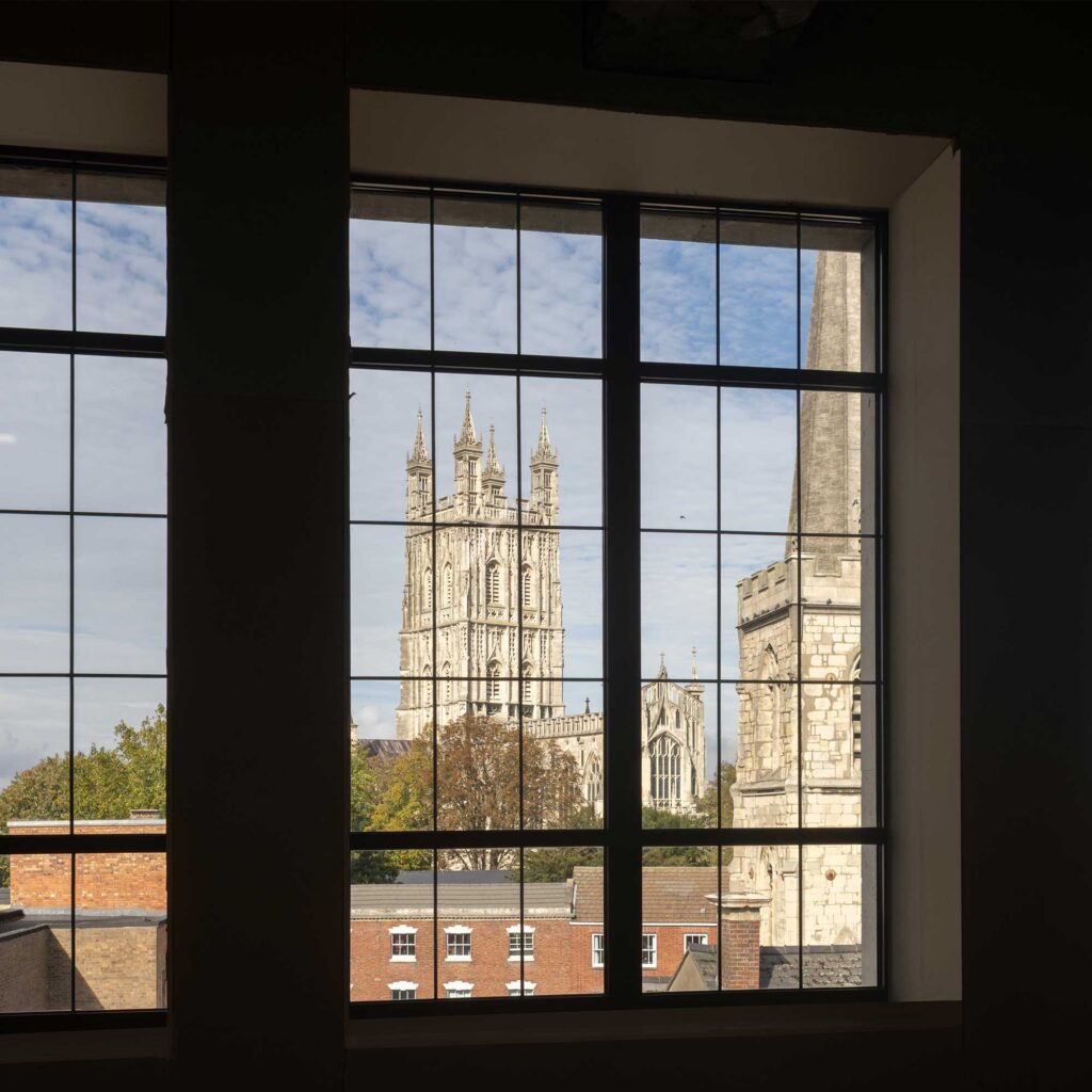 View of Gloucester Cathedral and church through a pane glass window.